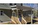 Comfortable covered back porch with wood railing, ceiling fan, and outdoor furniture at 108 Nakoma Dr, Louisburg, NC 27549