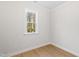 Bright, empty room with natural light, featuring hardwood floors and a window with a view of greenery at 108 Nakoma Dr, Louisburg, NC 27549