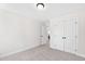 A bedroom with neutral carpet and two doors, one of which is a closet at 108 Nakoma Dr, Louisburg, NC 27549