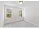 A spare bedroom with two windows and carpeted floors providing natural light at 108 Nakoma Dr, Louisburg, NC 27549