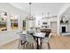 Bright dining area with modern chandelier, stylish table and chairs, and open view to the kitchen at 108 Nakoma Dr, Louisburg, NC 27549