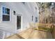 A view of the back deck shows a door and light fixture along with a railing and view of trees at 158 Nakoma Dr, Louisburg, NC 27549