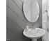 Bathroom featuring gray wall, mirror and pedestal sink with modern fixtures at 158 Nakoma Dr, Louisburg, NC 27549