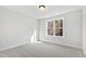 Bright bedroom with a large window providing ample natural light and neutral carpet at 158 Nakoma Dr, Louisburg, NC 27549