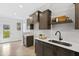 Contemporary kitchen with dark wood cabinetry, modern fixtures, and bright white backsplash at 158 Nakoma Dr, Louisburg, NC 27549