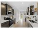 Modern kitchen featuring dark wood cabinets, stainless steel appliances, and sleek countertops at 158 Nakoma Dr, Louisburg, NC 27549