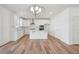 Bright, open kitchen with white cabinetry, island, modern lighting, and stainless appliances at 305 Chestnut Oak Ln, Lillington, NC 27546