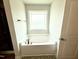 Bright bathroom features a soaking tub with a window providing natural light at 114 Southern Estates Dr, Sanford, NC 27330