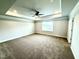 Large bedroom with tray ceiling, ceiling fan, and carpet flooring at 114 Southern Estates Dr, Sanford, NC 27330