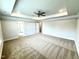 Large bedroom with tray ceiling, ceiling fan, and carpet flooring at 114 Southern Estates Dr, Sanford, NC 27330