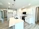 Modern kitchen with white cabinets, quartz counters, stainless appliances, and island with pendant lighting at 114 Southern Estates Dr, Sanford, NC 27330
