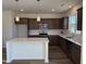 Modern kitchen with white countertops, stainless steel appliances, and dark wood cabinets at 32 Furley St., Homesite 53, Sanford, NC 27330