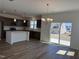 Open kitchen view featuring stainless steel appliances, a kitchen island, and laminate floors at 32 Furley St., Homesite 53, Sanford, NC 27330