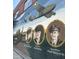 Brick wall mural honoring military personnel, featuring portraits and vintage airplanes at 32 Furley St., Homesite 53, Sanford, NC 27330
