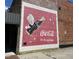 Brick wall displaying a vintage Coca-Cola ad mural with a cartoon character and the iconic slogan at 32 Furley St., Homesite 53, Sanford, NC 27330