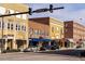 Street view showcases brick buildings with blue awnings and street signs under a cloudy sky at 32 Furley St., Homesite 53, Sanford, NC 27330