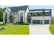 Elegant front exterior showcasing a manicured lawn, modern design, and spacious driveway and garage at 9009 Meadow Pointe Ct, Wake Forest, NC 27587