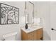 Stylish powder room with wood vanity and contemporary mirror at 9009 Meadow Pointe Ct, Wake Forest, NC 27587
