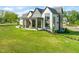 Expansive rear view showing the modern architecture, covered patio, and lush lawn of this luxurious home at 9009 Meadow Pointe Ct, Wake Forest, NC 27587