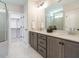 Stylish bathroom featuring double vanity, gray cabinets, walk-in closet access and marble floors at 1721 Grassy Falls Ln, Wendell, NC 27591
