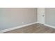 Neutral bedroom with wood floors, white trim, and white door to walk-in closet at 1721 Grassy Falls Ln, Wendell, NC 27591