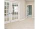 Bright bonus room features plush carpeting and glass panel doors at 1721 Grassy Falls Ln, Wendell, NC 27591