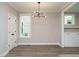 Well-lit dining room with sleek light fixture, hardwood floors, and a large window at 1721 Grassy Falls Ln, Wendell, NC 27591