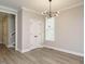Neutral dining room with modern chandelier, hardwood floors, and double door closet at 1721 Grassy Falls Ln, Wendell, NC 27591