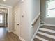 Bright entryway with hardwood floors, leading to stairs with wood railing and a white door at 1721 Grassy Falls Ln, Wendell, NC 27591
