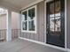 Inviting covered front porch with a modern black front door and bright window at 1721 Grassy Falls Ln, Wendell, NC 27591