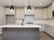 Bright kitchen featuring white cabinets, stainless steel appliances, and a gray island with a white countertop at 1721 Grassy Falls Ln, Wendell, NC 27591