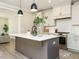 Modern kitchen featuring white cabinets, stainless steel appliances, and a gray island with a white countertop at 1721 Grassy Falls Ln, Wendell, NC 27591