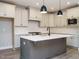 Spacious kitchen featuring white cabinets, stainless steel appliances, and a gray island with a white countertop at 1721 Grassy Falls Ln, Wendell, NC 27591