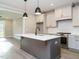 Modern kitchen featuring white cabinets, stainless steel appliances, and a gray island with a white countertop at 1721 Grassy Falls Ln, Wendell, NC 27591