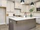 Spacious kitchen featuring white cabinets, stainless steel appliances, and a gray island with a white countertop at 1721 Grassy Falls Ln, Wendell, NC 27591