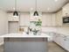 Bright kitchen featuring white cabinets, stainless steel appliances, and a gray island with a white countertop at 1721 Grassy Falls Ln, Wendell, NC 27591