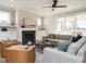Cozy living room with a fireplace, comfortable seating, and natural light streaming through large windows at 1721 Grassy Falls Ln, Wendell, NC 27591