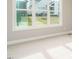 Bright living room featuring large windows offering backyard views, and neutral carpet flooring at 1721 Grassy Falls Ln, Wendell, NC 27591