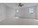 Spacious bedroom with neutral carpet, a ceiling fan, and two windows offering natural light and scenic views at 110 Summerlin Dr, Clayton, NC 27527