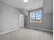 Cozy bedroom featuring soft carpeting, a well-lit window with a scenic view, and a convenient entry door at 110 Summerlin Dr, Clayton, NC 27527