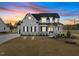 Beautiful two-story home showcasing elegant architectural details and a well-manicured lawn at sunset at 110 Summerlin Dr, Clayton, NC 27527