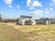 Exterior home view including the screened porch and a wide yard with clear skies in the background at 110 Summerlin Dr, Clayton, NC 27527
