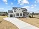 Exterior showcasing a light grey home with a paved driveway and neatly landscaped front yard at 110 Summerlin Dr, Clayton, NC 27527