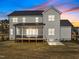 Twilight view of the home's rear exterior highlighting a screened porch and spacious backyard at 110 Summerlin Dr, Clayton, NC 27527