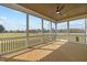 Relaxing screened porch features wood flooring, ceiling fan, and expansive views of the surrounding landscape at 110 Summerlin Dr, Clayton, NC 27527
