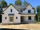 New construction: Charming two-story home featuring white siding, black-framed windows, and a welcoming front porch at 28 Bar Code Ct, Wendell, NC 27591