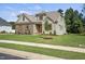 Charming home featuring a beautifully landscaped lawn and a mix of stone and siding exterior at 112 Lambert Ln, Fuquay Varina, NC 27526