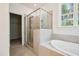 Bright bathroom featuring a glass shower, soaking tub, and a large window with tree views at 73 Artic Cir, Garner, NC 27529