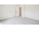 Empty carpeted bedroom with neutral walls, natural light, and double doors leading to closet at 73 Artic Cir, Garner, NC 27529