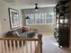 Cozy bonus room with a comfortable couch, shelving, and natural light from three windows at 73 Artic Cir, Garner, NC 27529
